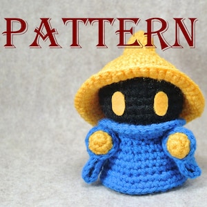 Puede incluir: Juguete amigurumi de crochet negro y amarillo con una túnica azul y un sombrero amarillo puntiagudo. El juguete tiene dos círculos amarillos para los ojos.