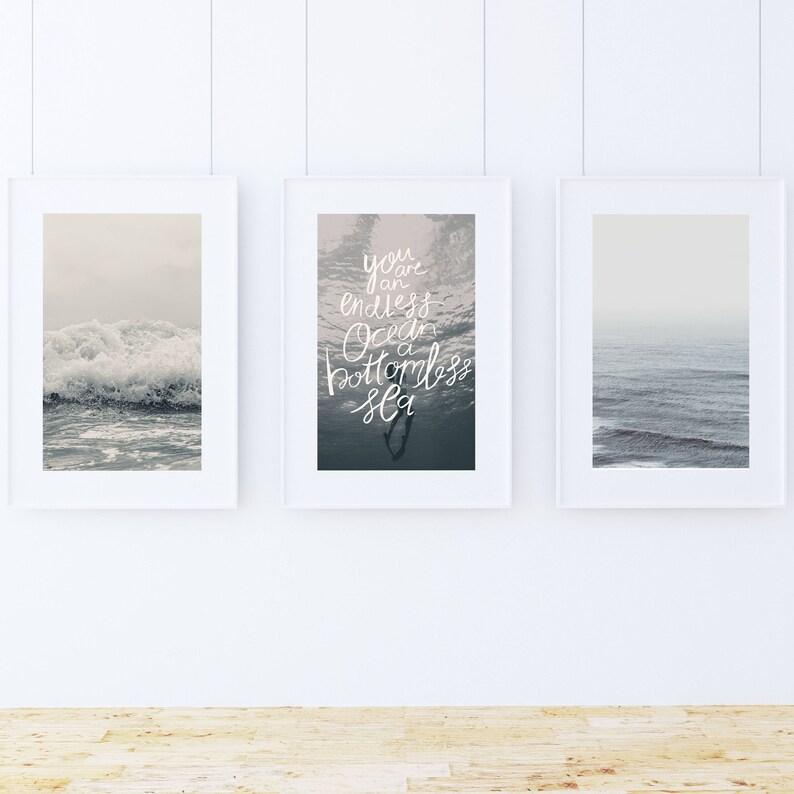 May include: Three framed prints with ocean scenes. The center print features a quote: "You are an endless ocean, a bottomless sea".