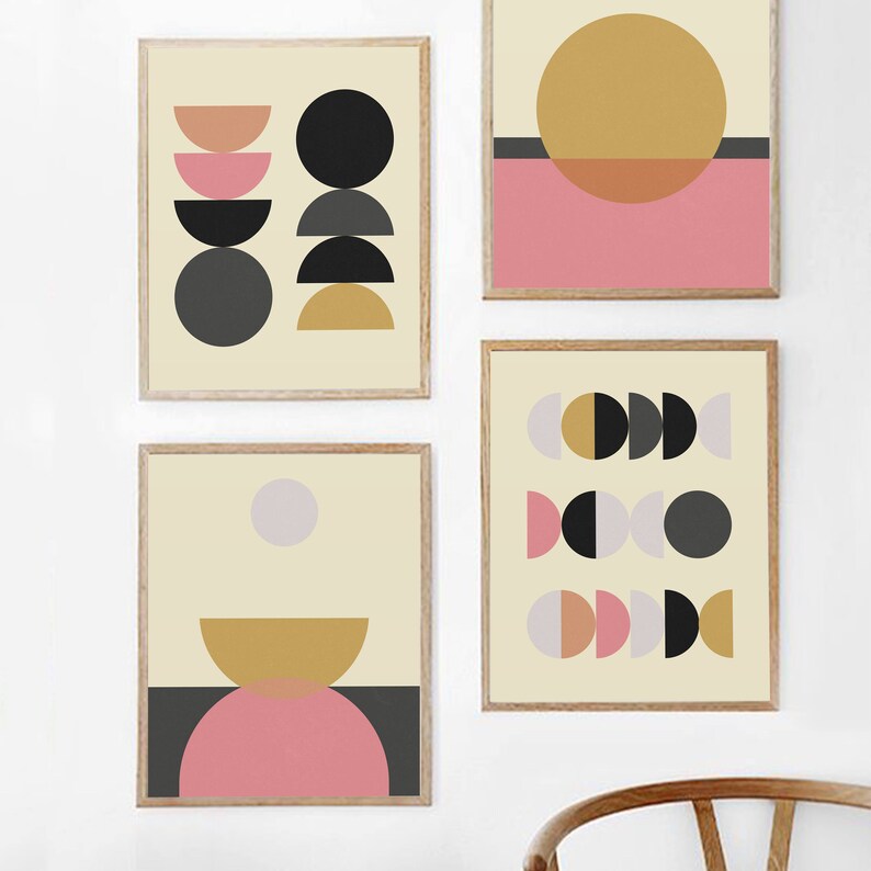 May include: Four framed prints with abstract geometric designs in black, white, gray, pink, and gold. The prints feature circles, half circles, and other geometric shapes.