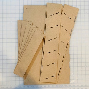 May include: A set of unfinished wooden pieces for building a shelf unit. The pieces are cut and ready to be assembled.