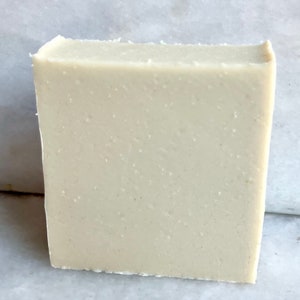 May include: A rectangular bar of white soap with a slightly grainy texture.