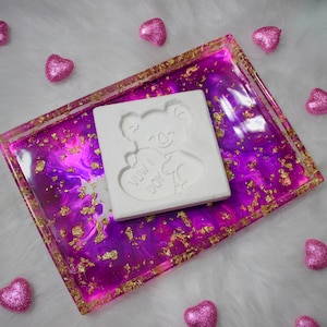 May include: A white resin tray with a pink and purple marbled design and gold flecks. The tray has a white koala bear mold with the words "Mum I Love You" inside. The tray is surrounded by pink heart-shaped decorations.