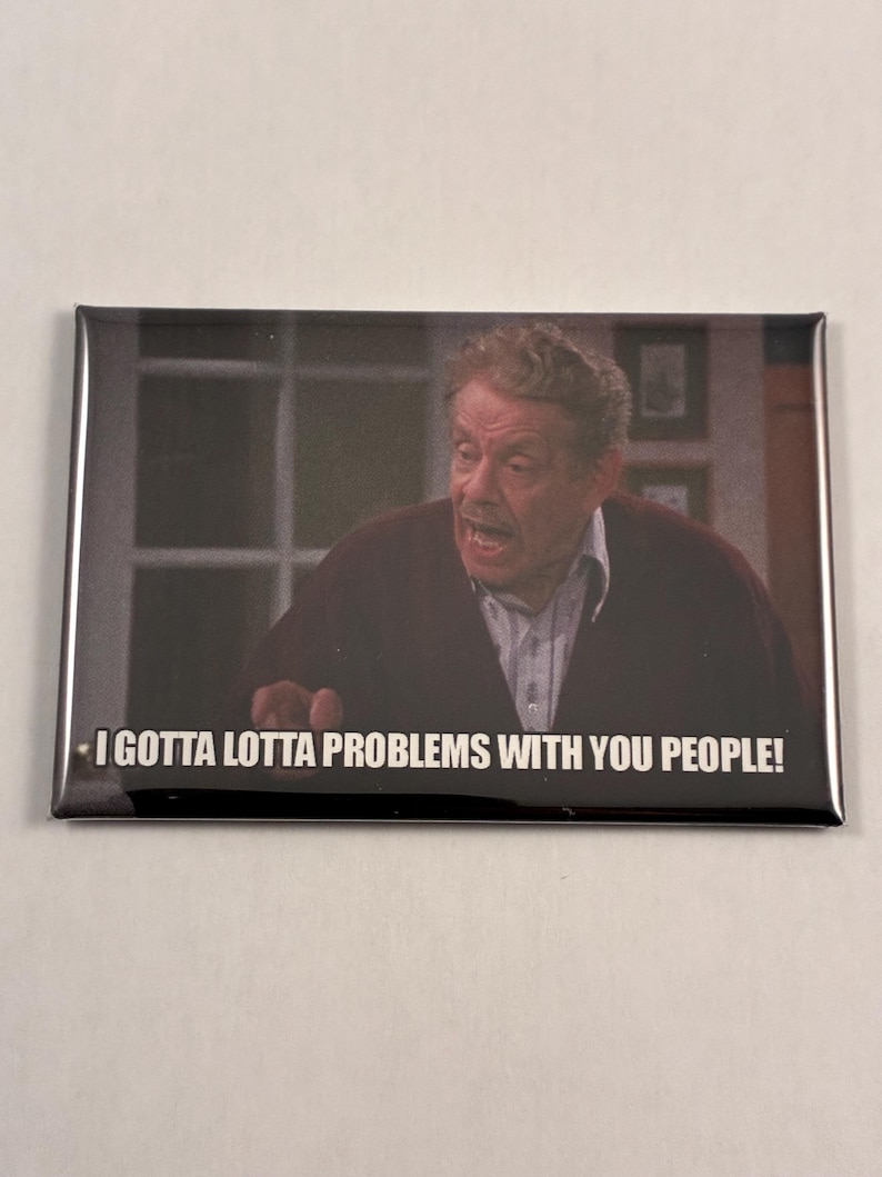 May include: Rectangular magnet featuring a man with an animated expression. The text "I GOTTA LOTTA PROBLEMS WITH YOU PEOPLE!" is printed in white on the bottom of the magnet. The man is wearing a burgundy sweater.