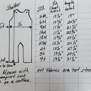 Peut inclure: Un tableau manuscrit avec des mesures pour une combinaison. Le tableau comprend des tailles de 3M &agrave; 4+, avec des mesures de poitrine/taille en pouces et une longueur totale en pouces. Le texte indique : &laquo; Mesurer avec la combinaison &agrave; plat sur une surface &raquo;.