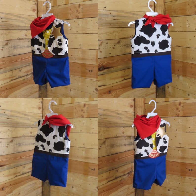 May include: A cowboy-themed costume set, including a vest with a cowhide pattern, blue shorts, and a red bandana. The vest features a brown belt design. The costume is displayed on a white hanger against a wooden background.