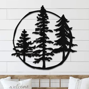 May include: Black metal wall art featuring three stylized pine trees inside a circle. The trees are silhouetted against a white background.