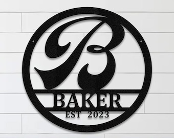 May include: Black metal round sign with a stylized letter B and the name "BAKER" with the text "EST 2023" below. The sign is hanging on a white wall above a wooden bench with pillows.