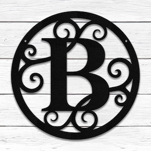 May include: Black metal monogram with a decorative scroll design and the letter "B" in the center. The monogram is circular and has a rustic look.