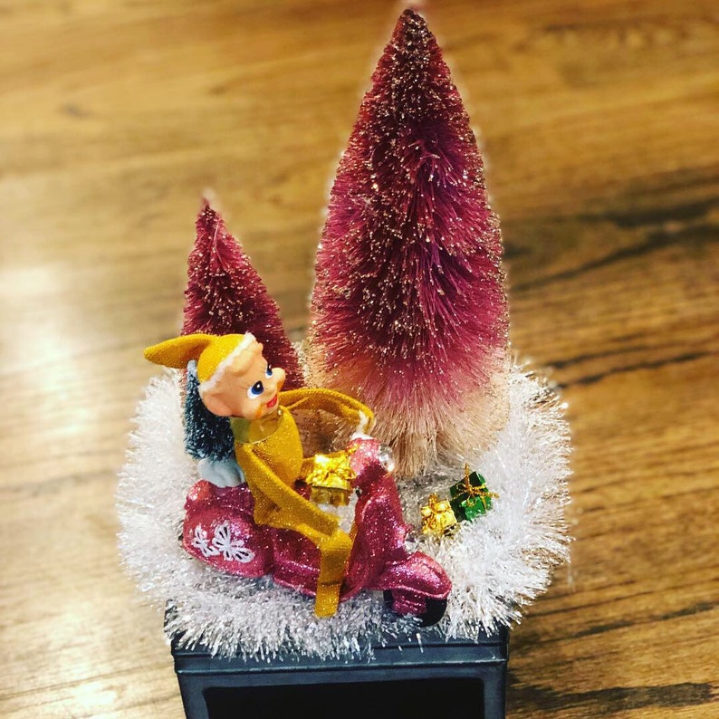 Vintage Pixie Elf knee hugger rides a pink scooter on kistch tabletop decor