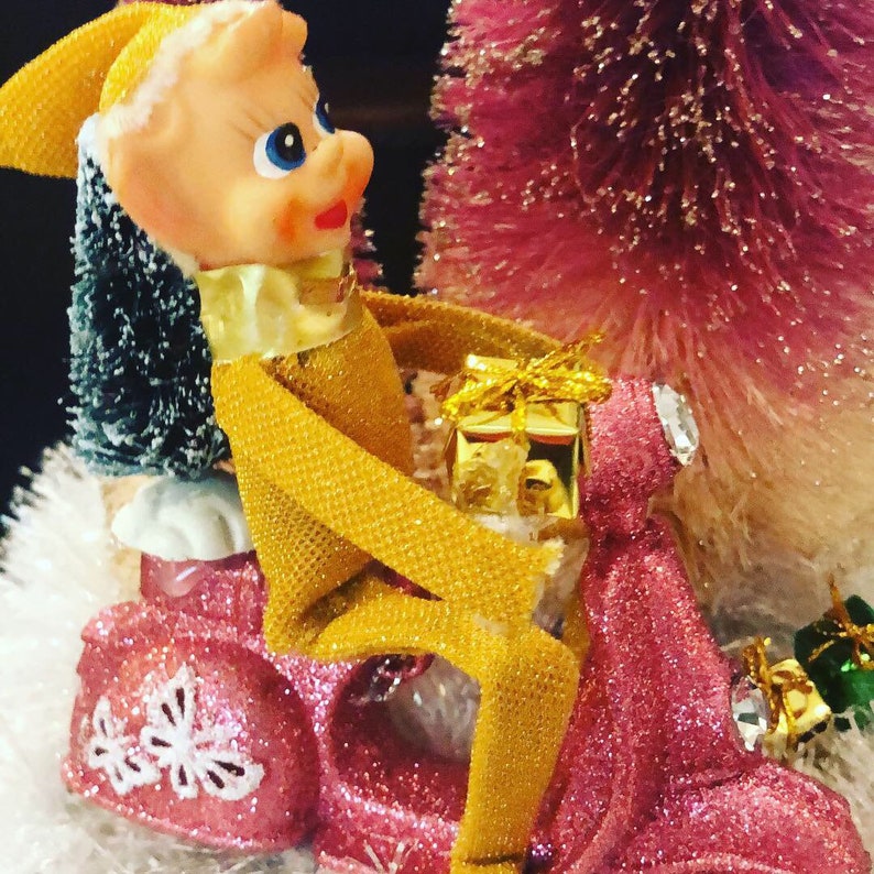Vintage Pixie Elf knee hugger rides a pink scooter on kistch tabletop decor