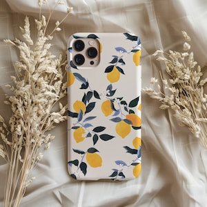 Puede incluir: Una funda de teléfono blanca con un patrón de limón y hojas. La funda tiene un recorte para el objetivo de la cámara y un fondo blanco.