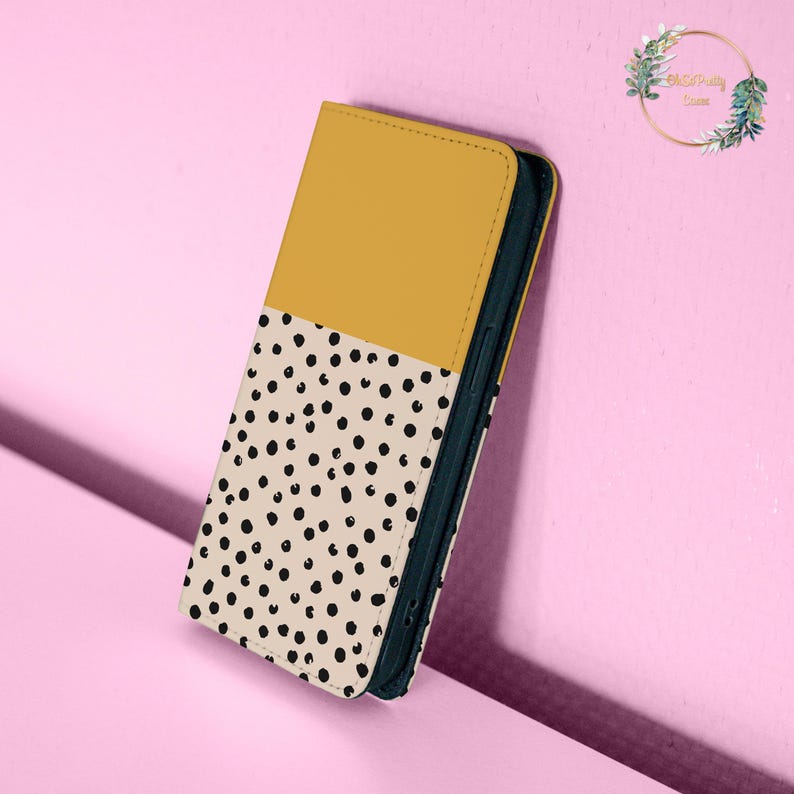 May include: A yellow and white phone case with a black polka dot pattern. The case is made of a soft, durable material and is designed to protect your phone from scratches and bumps.