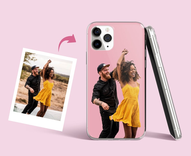 Pode incluir: Uma capa transparente para telefone com uma foto de um casal dan&ccedil;ando. A foto mostra um homem e uma mulher em um campo, a mulher est&aacute; usando um vestido amarelo e o homem est&aacute; usando uma camisa preta. A capa &eacute; rosa e tem uma borda preta.