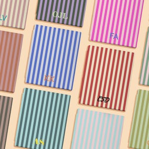 May include: A collection of rectangular items featuring vertical stripes in various color combinations including pink, blue, red, green, and brown. Each item displays unique two or three-letter monograms in contrasting colors printed on the front.