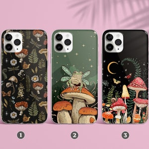 May include: Three different iPhone cases featuring a nature theme. The first case has a dark background with a pattern of mushrooms, ferns, dragonflies, and other woodland elements. The second case has a green background with a frog sitting on a mushroom. The third case has a black background with a pattern of mushrooms, ferns, and stars.