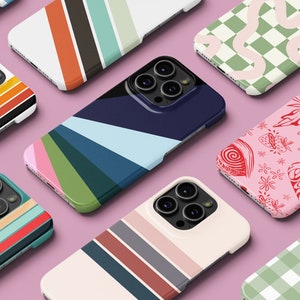 May include: Assortment of colourful phone cases with various geometric and abstract designs. The cases feature stripes, chequered patterns, and swirls.