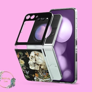 May include: A silver and black Samsung Galaxy Z Flip phone case with a skull and butterfly design. The case has a black background with a detailed illustration of a human skull, butterflies, and flowers. The phone is partially open, revealing the screen.