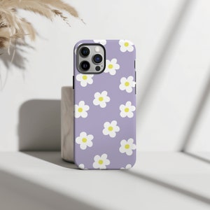 May include: A purple phone case with a white daisy pattern.