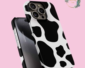 May include: A white and black cow print phone case for an iPhone with a camera bump. The case is made of a hard plastic material and has a smooth finish.