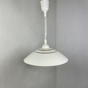 Könnte beinhalten: Weiße Hängelampe mit einem weißen, spiralförmigen Kabel und einem weißen, tellerförmigen Schirm.