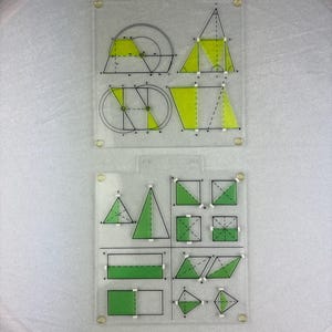 Op de afbeelding: Twee transparante geometrische sjablonen van acryl met verschillende vormen en hoeken. De vormen zijn zwart omlijnd met gele en groene vulling. De sjablonen zijn bevestigd met zilveren klinknagels.