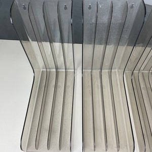 Pu&ograve; includere: Set di tre porta riviste in plastica trasparente con un design curvo. Ogni porta riviste ha sei fessure per riviste o altri oggetti.