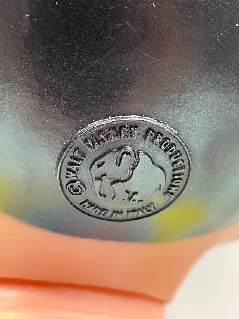 May include: Close-up of a black plastic label with the text "Walt Disney Productions" and a cartoon elephant logo. The label also says "Made in Italy".