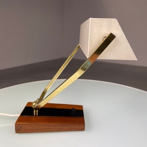 May include: A brass and wood desk lamp with a white shade. The lamp has a simple, geometric design and is in good condition.