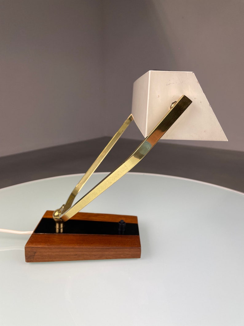 May include: A brass and wood desk lamp with a white shade. The lamp has a simple, geometric design and is in good condition.