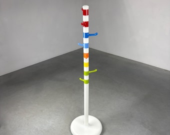 Può includere: Un attaccapanni colorato con base e palo bianchi. Il palo è decorato con strisce e ganci rossi, blu, gialli e verdi. I ganci sono in colori coordinati. L'attaccapanni è autoportante.