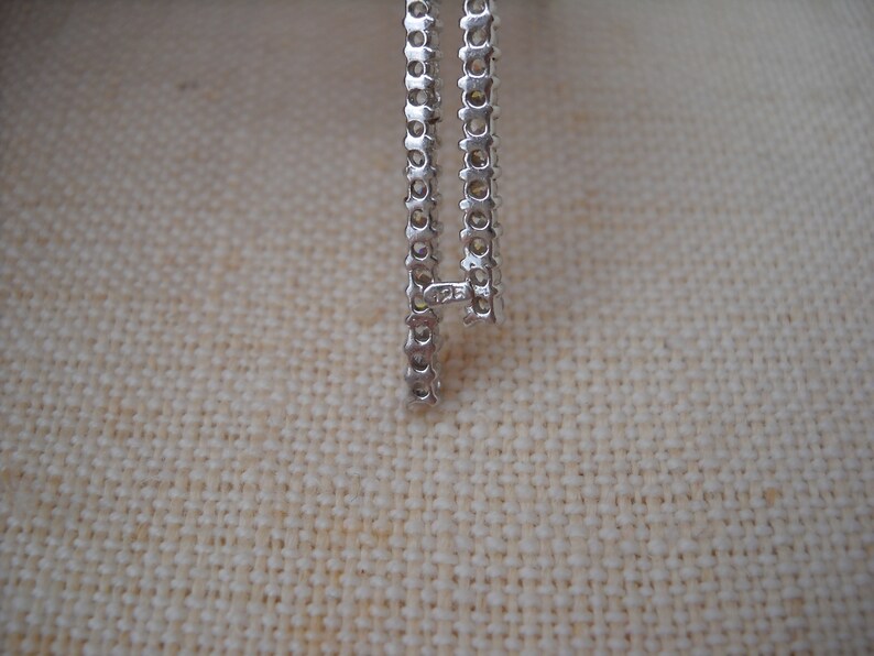 Pode incluir: Close-up de uma corrente de prata com um fecho que diz "125".