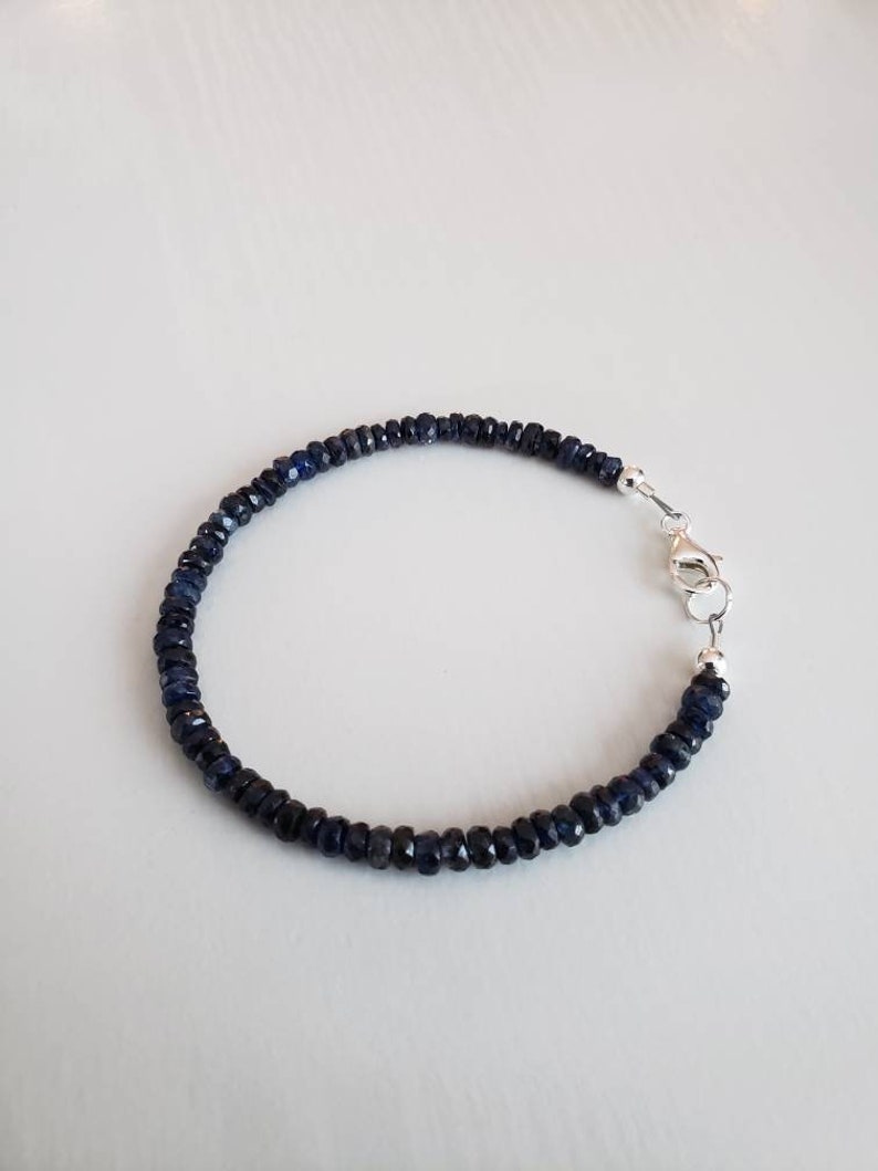 K&ouml;nnte beinhalten: Ein Armband aus dunkelblauen Saphiren mit einem silbernen Verschluss.