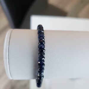 K&ouml;nnte beinhalten: Ein dunkelblaues Armband aus kleinen, facettierten Edelsteinen.