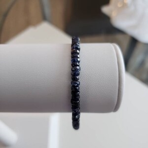 K&ouml;nnte beinhalten: Ein dunkelblaues Edelstein-Armband mit kleinen, facettierten Perlen.