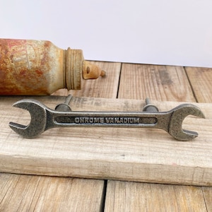 May include: A silver wrench-shaped cabinet pull with the words "Chrome Vanadium" engraved on the handle.