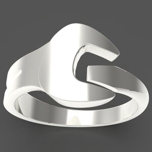 May include: A silver ring shaped like a spanner.