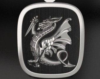 May include: A silver pendant with a black background featuring a detailed silver dragon holding a dagger.