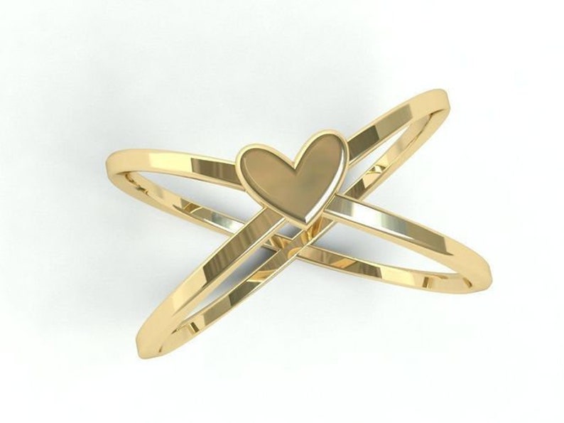 K&ouml;nnte beinhalten: Goldfarbener Ring mit herzf&ouml;rmigem Mittelteil. Der Ring hat zwei sich kreuzende B&auml;nder, die ein X bilden. Das Herz befindet sich in der Mitte der B&auml;nder.