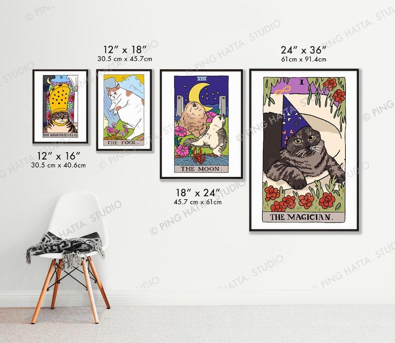 May include: Four framed prints of cat tarot cards. The cards are titled "The High Priestess", "The Fool", "The Moon", and "The Magician". Each card features a cat in a different pose and setting. The cards are framed in black frames and are hung on a white wall.
