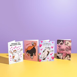 Puede incluir: Cuatro tarjetas de felicitaci&oacute;n con ilustraciones de gatos. Las tarjetas presentan frases como "Sending you big, chonky hugs!" y "Congrats to the purrfect pair." Cada tarjeta tiene un dise&ntilde;o &uacute;nico con corazones y gatos de dibujos animados.