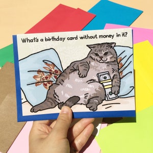 Qu'est-ce qu'une carte d'anniversaire sans argent - gros chat tenant une carte d'anniversaire avec de l'argent, meme chat riche, carte d'anniversaire chat cash, anniversaire chat grossier