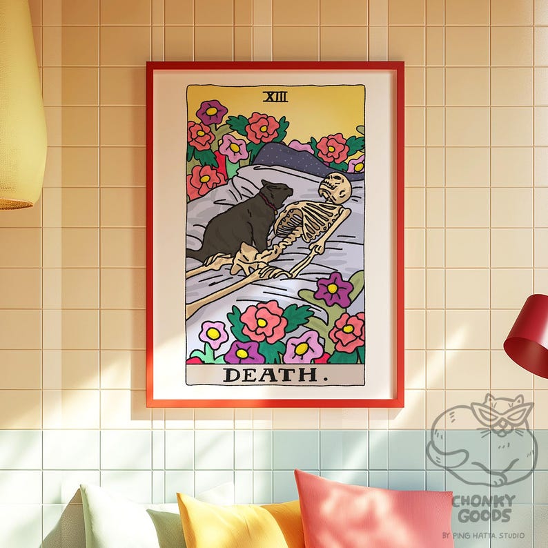 May include: A tarot card illustration depicting Death, the 13th card in the Major Arcana. The card features a skeleton lying in a bed of flowers with a black cat curled up beside it. The card is framed in red and has the word "DEATH" printed in black at the bottom.