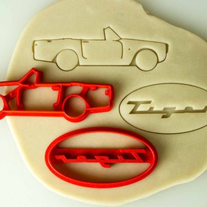 May include: Red plastic cookie cutters shaped like a convertible car and the word "Tiger" in an oval.