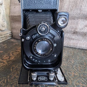Zeiss Ikon Cocarette. Deral Nostar 1.6.3 F =10.5 cm Fotocamera pieghevole con custodia in pelle