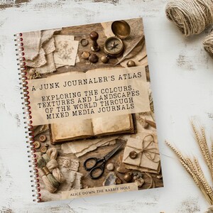 May include: A spiral-bound book titled A JUNK JOURNALER'S ATLAS EXPLORING THE COLOURS, TEXTURES AND LANDSCAPES OF THE WORLD THROUGH MIXED MEDIA JOURNALS by ALICE DOWN THE RABBIT HOLE, featuring a cover image of an open book, compass, and scissors.