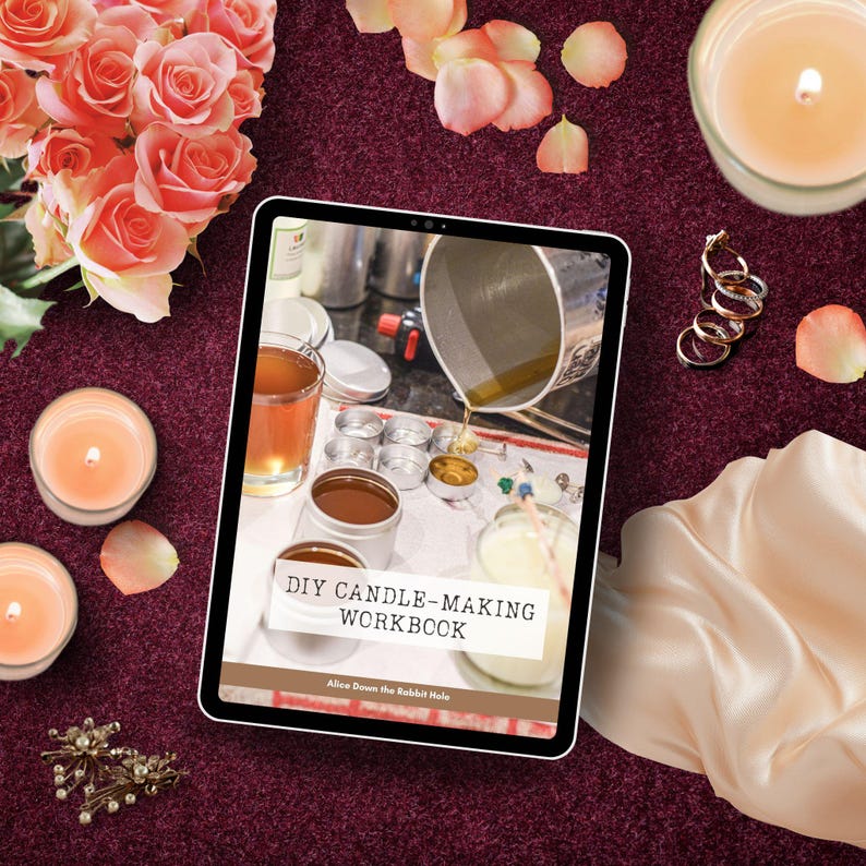 Peut inclure: Une tablette num&eacute;rique affichant un classeur de fabrication de bougies DIY avec le titre "DIY Candle-Making Workbook" et l'auteur "Alice Down the Rabbit Hole". La tablette est entour&eacute;e de bougies, de p&eacute;tales de roses et d'autres fournitures artisanales.