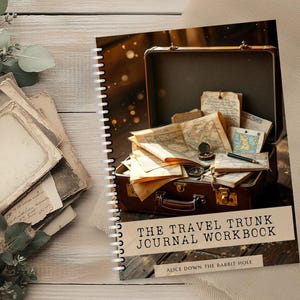 May include: A spiral-bound journal titled "THE TRAVEL TRUNK JOURNAL WORKBOOK" with a vintage suitcase illustration. The suitcase is filled with maps, a compass, and old papers. The journal is on a wooden surface with greenery.