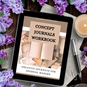 Może przedstawiać: Tablet wyświetla okładkę zeszytu ćwiczeń zatytułowanego "Concept Journals Workbook" ze sloganem "Creative Journeys for Journal Makers". Obraz otoczony jest fioletowymi kwiatami, długopisem, okularami i zapaloną świecą, tworząc kreatywną atmosferę.
