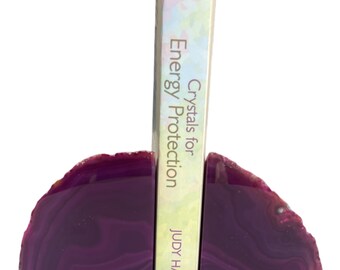May include: Purple agate bookends with a book titled "Crystals for Energy Protection" by Judy Hall. The book is published by Hay House.