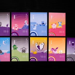 Könnte beinhalten: Acht bunte Karten mit verschiedenen Pokémon-Charakteren auf jeder. Die Karten sind in zwei Reihen zu je vier angeordnet. Jede Karte hat einen Buchstaben und eine Nummer darauf. Die Karten sind alle in verschiedenen Farben, darunter Lila, Blau, Grün, Gelb und Pink.